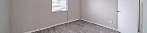 an empty living room with wood flooring and a white door