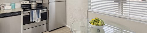 a kitchen with stainless steel appliances and a glass table