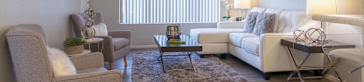 A living room with couches and chairs and a table at Westmount at Urban Trails, Mesa, AZ
