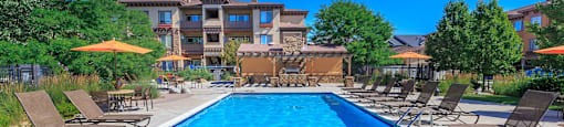 A large swimming pool surrounded by lounge chairs and umbrellas.