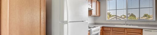 a kitchen with white appliances and wooden cabinets