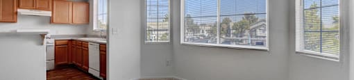 an empty living room and kitchen with a large window