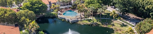 A view of a resort with a pool and palm trees.
