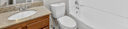 A white bathroom with a sink, toilet, and bathtub.