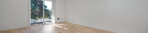 a bedroom with hardwood floors and white walls at The Crest at Citrus Heights Apartments, California