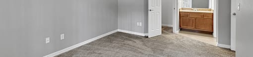 A room with a carpeted floor and a wooden cabinet.