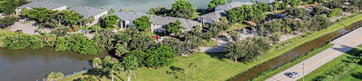 A large body of water surrounded by houses and trees. at Cascades at Clear Lake Apartments, Ft. Myers, Florida