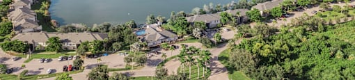 A large body of water surrounded by greenery and buildings. at Cascades at Clear Lake Apartments, Florida, 33908