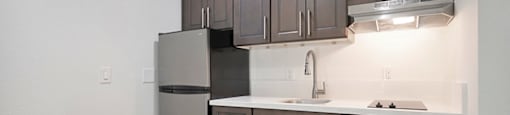 a kitchen with dark cabinets and white countertops at Citrus Heights Apartments, Citrus Heights, CA