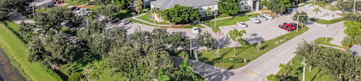 A large lake is surrounded by houses and trees. at Cascades at Clear Lake Apartments, Ft. Myers, 33908