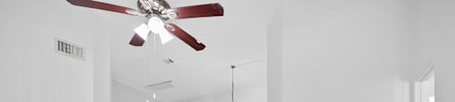 A room with a ceiling fan and a light hanging from the ceiling.