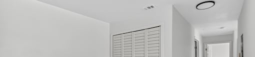 A long hallway with a white door and a white wall. at Cascades at Clear Lake Apartments, Florida
