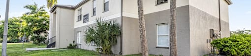A building with a palm tree in front of it. at Cascades at Clear Lake Apartments, Ft. Myers, Florida