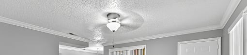 A room with a white ceiling fan and a white door.