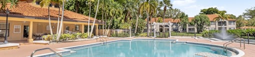 A large outdoor swimming pool surrounded by palm trees.