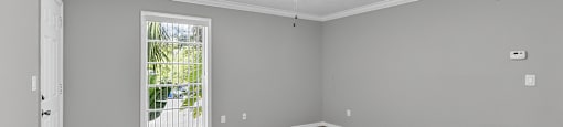 A room with a carpeted floor and a window showing a patio.