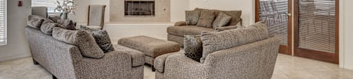 A living room with a fireplace and grey couches.