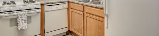 A kitchen with wooden cabinets and white appliances.