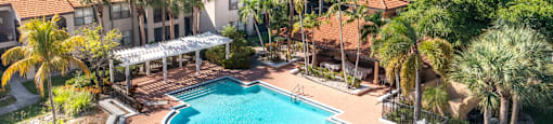 A large swimming pool surrounded by a deck and a covered patio area.