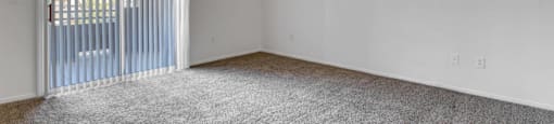 A room with a ceiling fan and carpeted floor.
