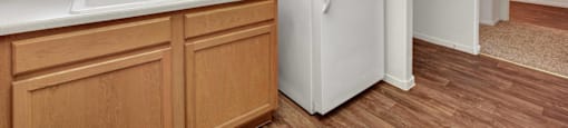 A kitchen with a white fridge and wooden cabinets.