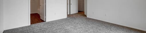 A room with a ceiling fan and carpeted floor.