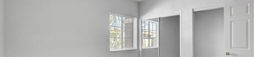 A room with a carpeted floor and a door on the right side.