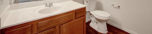 A white toilet sits next to a sink in a bathroom.