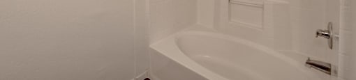 A white bathroom with a bathtub and a shower.