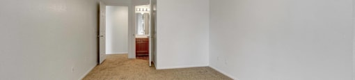 A room with a carpeted floor and a ceiling fan.