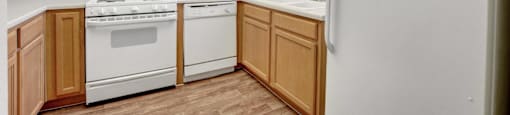 A kitchen with wooden cabinets and white appliances.