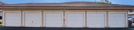 A building with a brown roof and white garage doors.