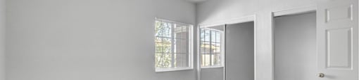 A room with a carpeted floor and a door on the right side.