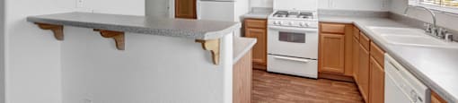 A kitchen with white appliances and wooden cabinets.