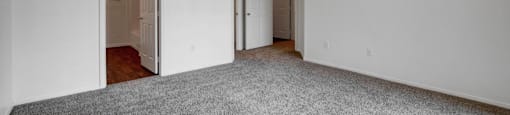 A room with a ceiling fan and carpeted floor.