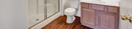 A bathroom with a toilet, sink, and mirror.