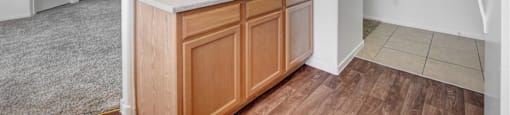 A kitchen area with a white fridge, wooden cabinets and a marble countertop.