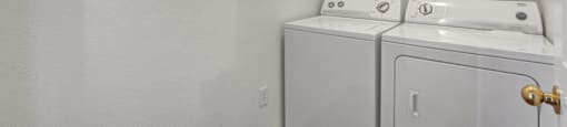 A white bathroom with a washer and dryer.