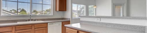 A kitchen with wooden cabinets and a white dishwasher.