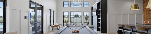 A billiard table is in the middle of a room with a pool table light.