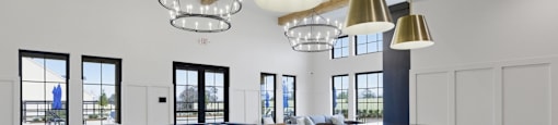 A modern kitchen with a large island and pendant lights.