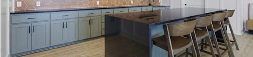 A kitchen with a long island and chairs.