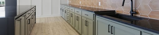 A kitchen with a black counter top and wooden shelves.
