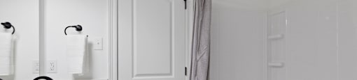 A white bathroom with a white tub and a white sink.