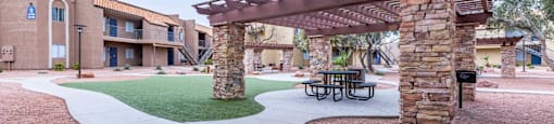 A patio with a table and chairs under a pergola.