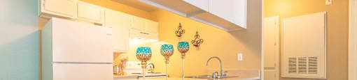A kitchen with white cabinets and a white fridge.