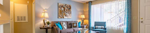 A living room with a grey couch and a wooden coffee table.
