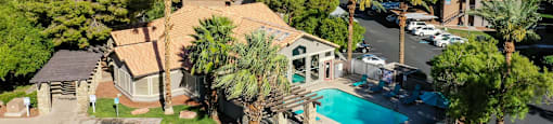 A bird's eye view of a residential area with a swimming pool and palm trees.