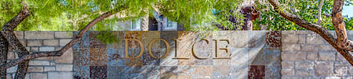 A stone wall with the word "DOLCE" written on it.