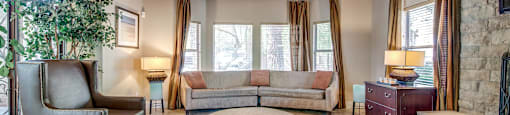 A living room with a couch, chair, and fireplace.